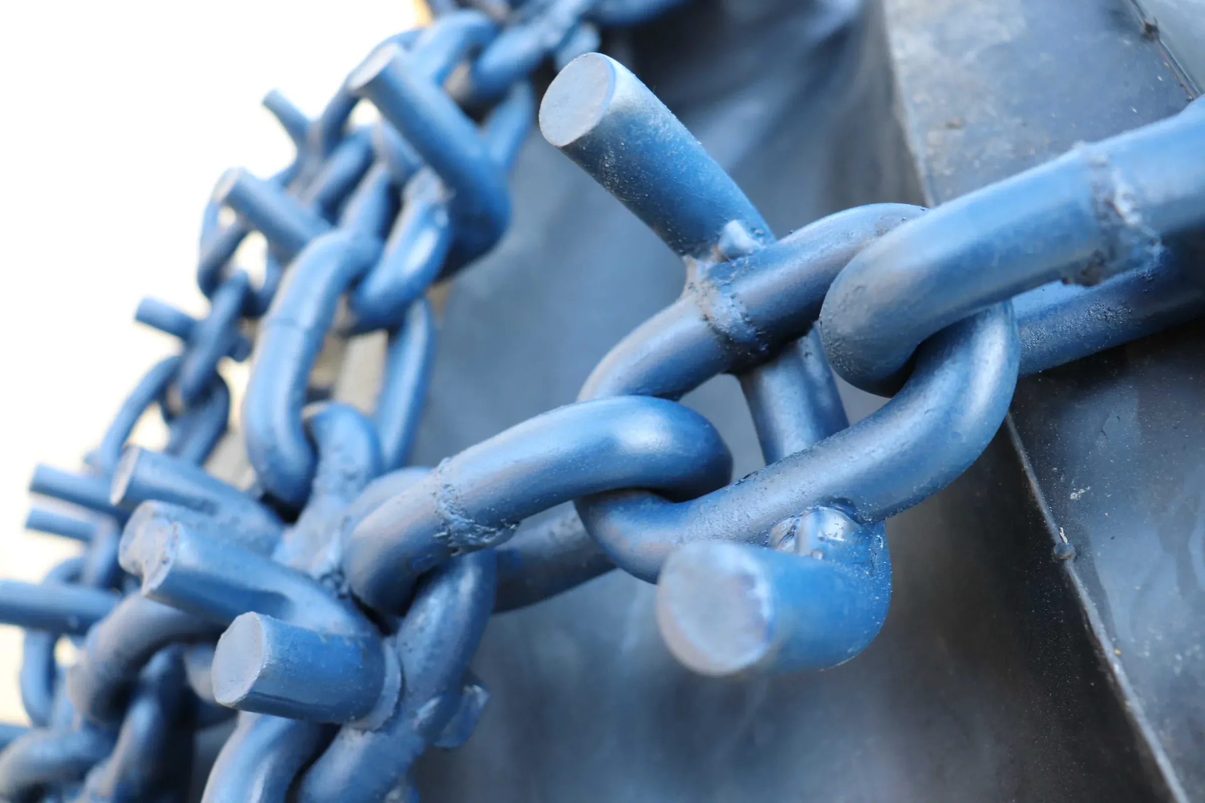 Close-up of a blue XL Chains chain fitted to a forestry machine tyre